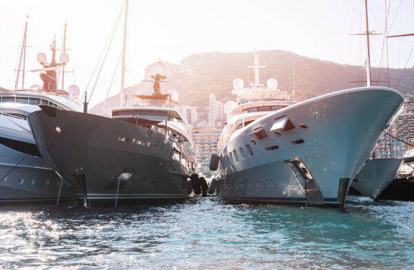 Zwei Superyachten liegen im Hafen nebeneinander im Gegenlicht vertaeut