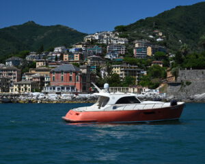 Rot-weisse Motoryacht vor dem bunten Kuestenort Portofino