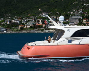 Weiss-rote Motoryacht in Fahrt entlang der gruenen Portofino-Kueste