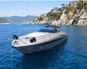 Graue Riva Rivale 52 vor der bewaldeten Kueste bei Portofino in Frontansicht