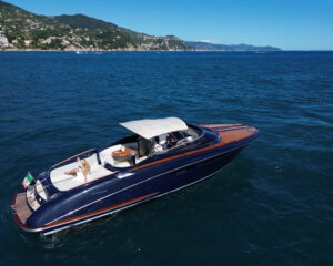 Blaue Motoryacht mit Holzdetails und Sonnenverdeck vor der Portofino-Kueste