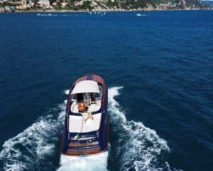 Riva Motoryacht von oben in Fahrt vor der gruenen Portofino-Kueste, Luftaufnahme