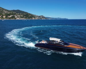 Riva Motoryacht mit Holzdeck in Fahrt entlang der Portofino-Kueste, Luftaufnahme