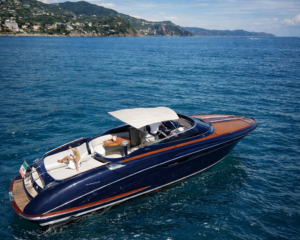 Blau-holzfarbene Riva-Yacht vor der Kueste der ligurischen Riviera