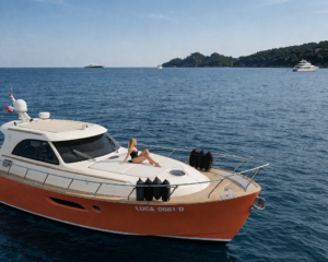 Orange-weisse klassische Motoryacht vor Anker im ruhigen Wasser vor Portofino